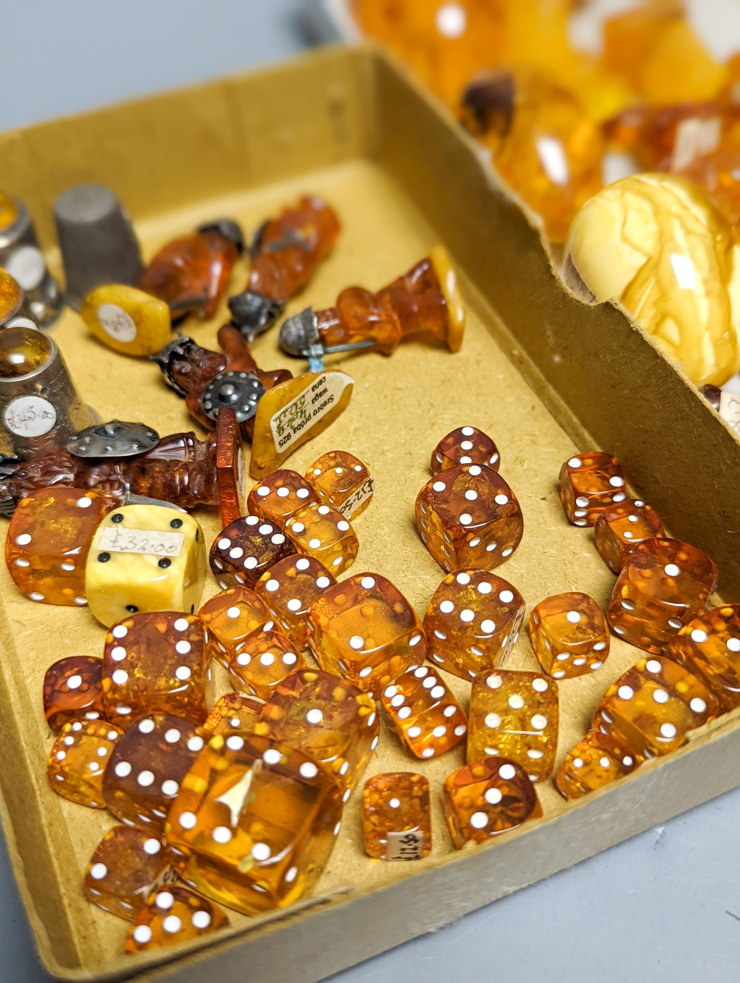 A mixed collection small carved amber wares including dice, eggs and cigarette holders, etc.
